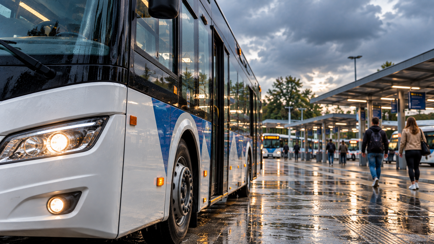 Bus à l’arrêt dans une gare routière sous la pluie, illustration des transports en Provence Verte.